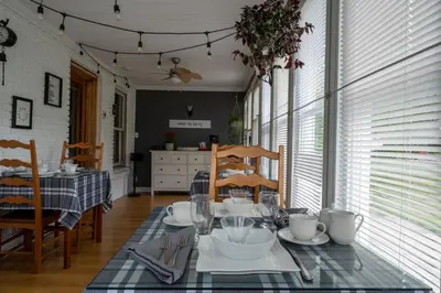 a dining room with a table and chairs and a kitchen at Au coq du bonheur in Magog-Orford