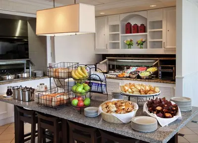 a buffet of food on a counter in a kitchen at Hilton Garden Inn Montreal Airport in Dorval