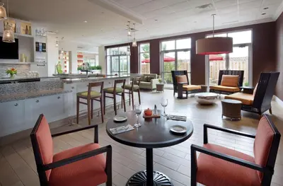 a kitchen and living room with a table and chairs at Hilton Garden Inn Montreal Airport in Dorval
