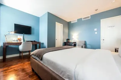 a bedroom with blue walls and a bed and a desk at Auberge de La Fontaine in Montréal