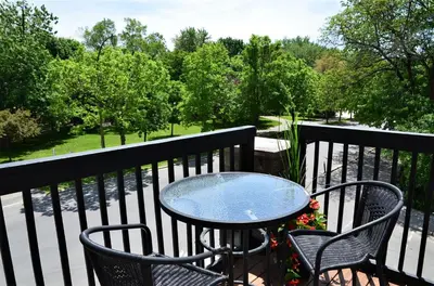 a table and chairs on a balcony with trees at Auberge de La Fontaine in Montréal