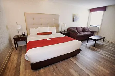 a hotel room with a large bed and a couch at Hotel Europa, BW Signature Collection in Montréal