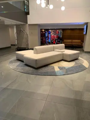 a living room with a white couch on a rug at Hotel Europa, BW Signature Collection in Montréal