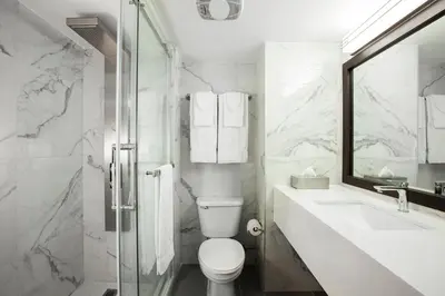 a bathroom with a toilet and a sink and a shower at Le Nouvel Hotel in Montréal