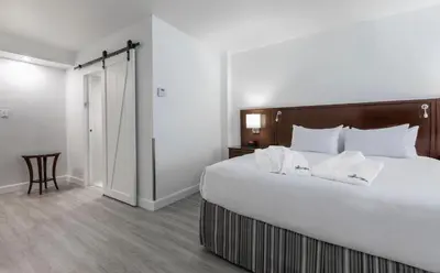 a bedroom with a large white bed with white pillows at Le Nouvel Hotel in Montréal
