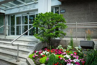 a tree in a flower bed in front of a building at Le Nouvel Hotel in Montréal