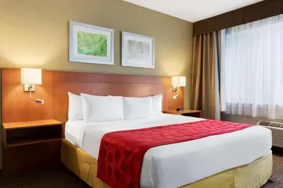 a hotel room with a large bed with a red blanket at Ramada Plaza by Wyndham Montreal in Montréal