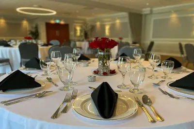 a table with a white table cloth with plates and silverware at Ramada Plaza by Wyndham Montreal in Montréal