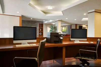 two computer monitors sitting on a desk with chairs at Ramada Plaza by Wyndham Montreal in Montréal