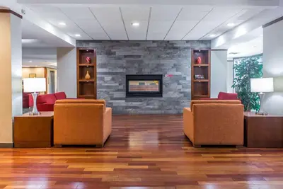 a waiting room with chairs and a fireplace at Ramada Plaza by Wyndham Montreal in Montréal