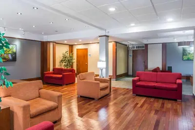 a waiting room with two chairs and couches at Ramada Plaza by Wyndham Montreal in Montréal
