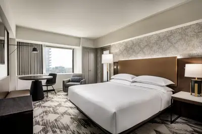 a bedroom with a large white bed and a desk at Le Centre Sheraton Montreal Hotel in Montréal