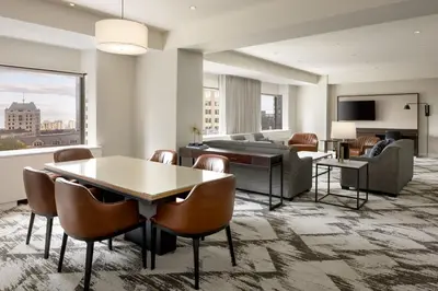 a living room with a couch and a table and chairs at Le Centre Sheraton Montreal Hotel in Montréal