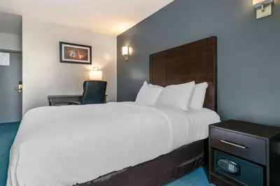 a hotel room with a large bed and a chair at Econo Lodge in Montréal