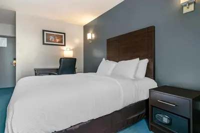 a hotel room with a large bed and a chair at Econo Lodge in Montréal