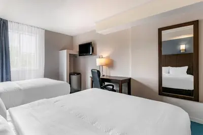 a hotel room with two beds and a mirror at Econo Lodge in Montréal