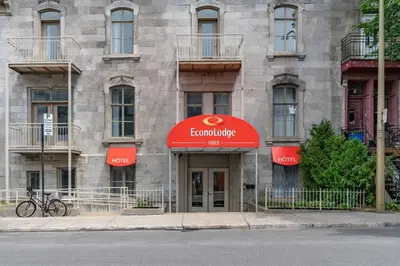 a building with a red sign in front of it at Econo Lodge in Montréal