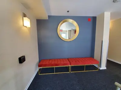 a waiting room with a red bench and a mirror at Econo Lodge in Montréal