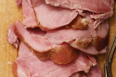 a pile of ham on a table with a fork at Auberge Les Bons Matins in Montréal