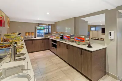 a large kitchen with a counter with food at Quality Inn Centre-Ville in Montréal