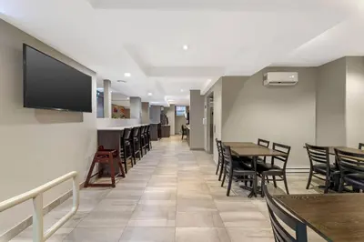 a dining room with tables and chairs and a flat screen tv at Quality Inn Centre-Ville in Montréal