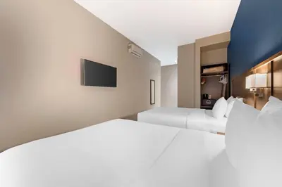 a hotel room with two beds and a tv at Quality Inn Centre-Ville in Montréal