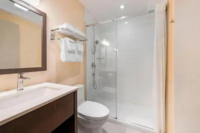 a bathroom with a shower and a toilet and a sink at Quality Inn Centre-Ville in Montréal
