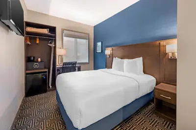 a bedroom with a large white bed and a desk at Quality Inn Centre-Ville in Montréal