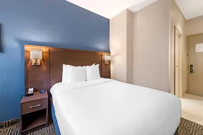 a large white bed in a hotel room at Quality Inn Centre-Ville in Montréal