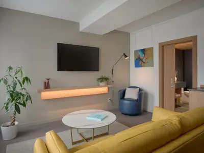 a living room with a yellow couch and a table at Hôtel de l'ITHQ in Montréal