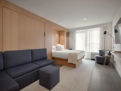 a hotel room with a bed and a couch at Hôtel de l'ITHQ in Montréal