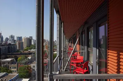a row of red chairs on the balcony of a building at Hôtel de l'ITHQ in Montréal