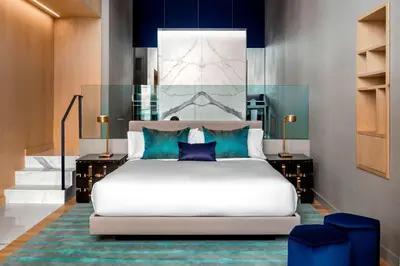 a bedroom with a large white bed with blue pillows at W Montreal in Montréal