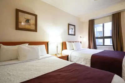 a hotel room with two beds and a window at Hotel St-Denis in Montréal
