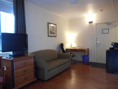 a living room with a couch and a flat screen tv at Hotel St-Denis in Montréal