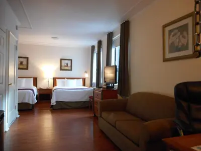 a hotel room with two beds and a couch at Hotel St-Denis in Montréal