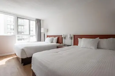 a hotel room with two beds and a window at Hotel les Suites Labelle in Montréal