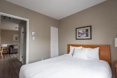 a bedroom with a large bed with white sheets at Hotel le Roberval in Montréal