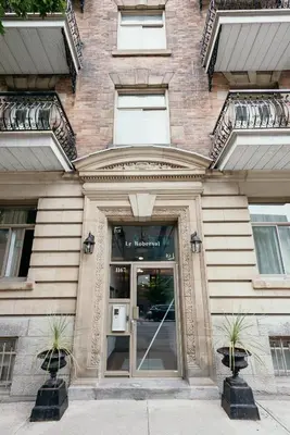 a building with a glass door in front of it at Hotel le Roberval in Montréal