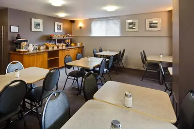 a dining room with tables and chairs and a counter at Hotel le Roberval in Montréal