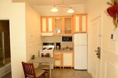 a kitchen with a table and a white refrigerator at Parc Suites Hotel in Montréal