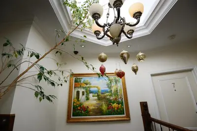 a painting hanging on a wall with a chandelier at Parc Suites Hotel in Montréal