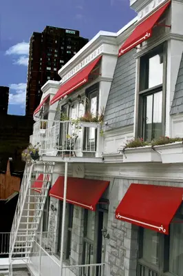 a building with red awnings on the side of it at Parc Suites Hotel in Montréal