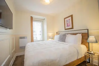 a bedroom with a large white bed and a window at Parc Suites Hotel in Montréal
