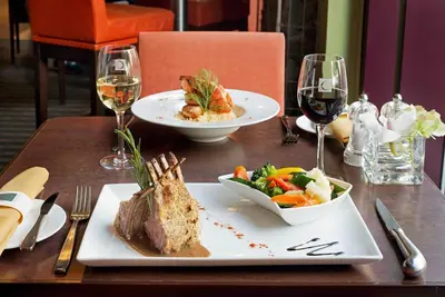 a table with a plate of food and glasses of wine at Novotel Montreal Center in Montréal