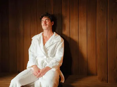 a man in a white robe sitting in a room at Sofitel Montreal Golden Mile in Montréal