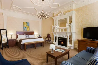 a hotel room with a bed and a fireplace at Chateau Versailles in Montréal