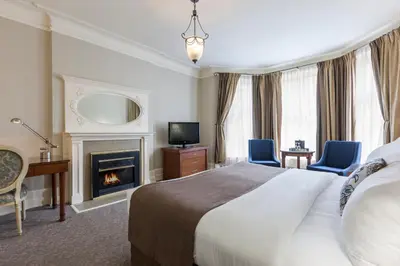 a hotel room with a bed and a fireplace at Chateau Versailles in Montréal
