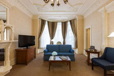 a living room with a blue couch and a tv at Chateau Versailles in Montréal