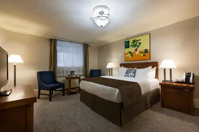 a hotel room with a bed and a television at Chateau Versailles in Montréal